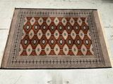 an image of a brown and black rug on a white tiled floor