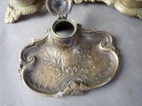a silver candle holder on a table next to a mirror