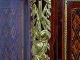 a gold leaf decoration on the top of a wooden cabinet