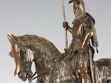 statue of a man on a horse with a flag on a stand