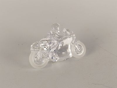 crystal figurine of a man on a motorcycle on a white surface