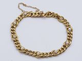 un bracelet en chaîne d'or orné de perles sur fond blanc