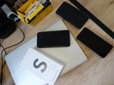 a table with a laptop, cell phone, and other electronics on it