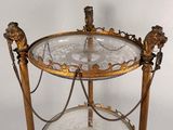 a glass table with a gold metal frame and a mirror on it