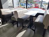 tables and chairs in a restaurant with a view of a parking lot