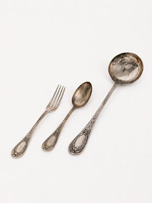 three spoons and a fork on a white surface
