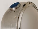 a close up of a metal object with a blue button on it
