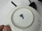 a person holding a white plate with a blue flower on it