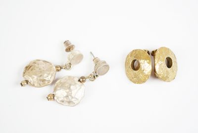 deux paires de boucles d'oreilles en or et en argent sur un fond blanc