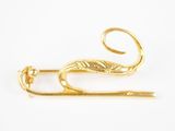 une broche en or ornée d'un serpent, sur un fond blanc