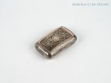 an antique silver cigarette case on a white surface