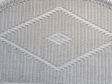 a white wicker chair with a diamond pattern on it