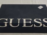 the box is black and white with the word guess written on it