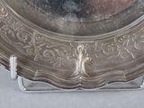 a silver plate on a stand with a mirror in the background