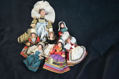 a lot of dolls that are sitting on a black surface