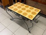 a small table with a tile top on a tile floor