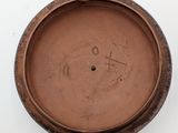 a brown bowl with writing on it sitting on a table