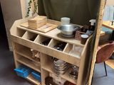 a wooden shelf with pots and pans on top of it