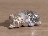 a small figurine of a cat laying on a table