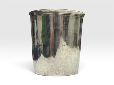 une vieille coupe en argent posée sur une table blanche