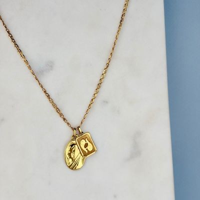 un collier plaqué or avec une petite pièce suspendue à une chaîne en or