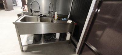 un évier en inox et un réfrigérateur en inox dans une cuisine