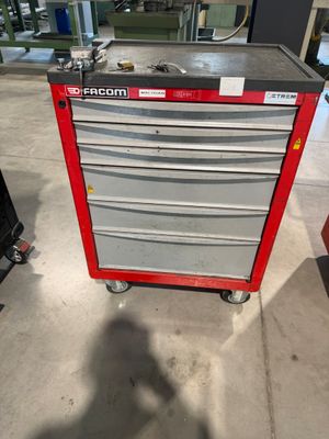 une boîte à outils rouge posée sur un chariot métallique