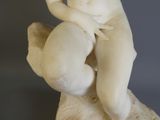 une statue de femme assise au sommet d'un rocher