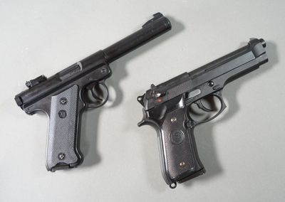 two guns that are sitting next to each other on a table