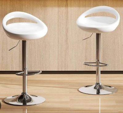 deux tabourets de bar blancs placés l'un à côté de l'autre sur un parquet