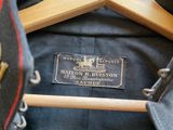 a jacket hanging on a wooden hanger with a badge on it