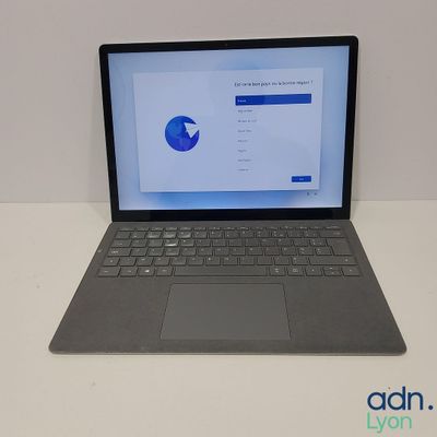 L'ordinateur portable est posé sur la table, l'écran ouvert.