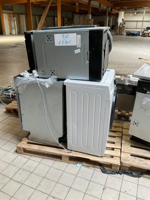 une pile d'appareils électroménagers posée sur une palette dans un entrepôt