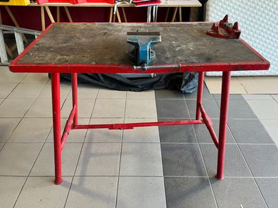 une table rouge sur laquelle repose une pièce de métal