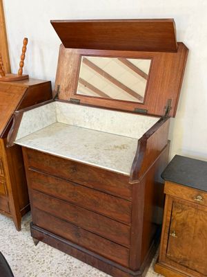 un coffre en bois surmonté d'un miroir