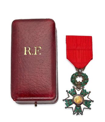une image représentant un écrin rouge orné d'une médaille en or et d'un ruban rouge