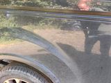 a reflection of a man in the window of an old car