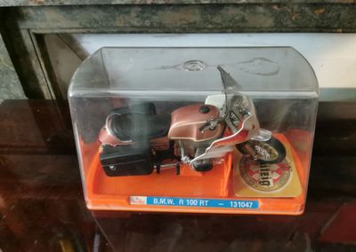 une moto miniature dans une boîte transparente posée sur une table