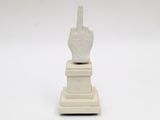 a statue of a hand holding a knife on a pedestal