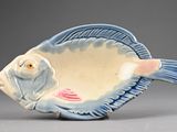 a blue and white fish shaped bowl on a gray surface