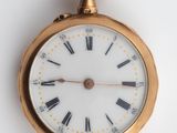une montre de poche en or avec des chiffres romains sur le cadran