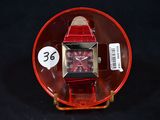 a red watch with a black face on a red plate