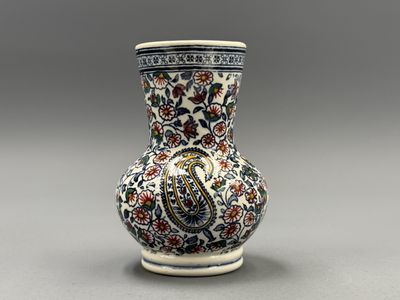 un vase orné d'un motif floral sur un fond gris