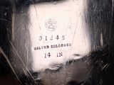 a close up of a silver vase with a label on it