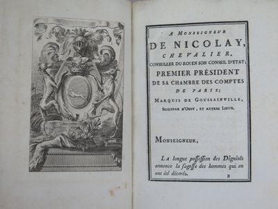 un livre ouvert sur lequel figure un blason