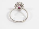 a close up of a silver ring with a ruby stone in the center