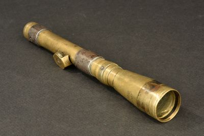 an old brass telescope on a black surface