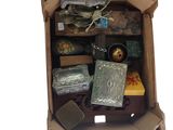 une boîte en carton remplie d'objets divers posée sur une surface blanche