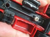 a hand holding a toy train that is red and black