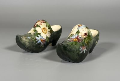 une paire de sabots ornés de fleurs peintes sur un fond gris
